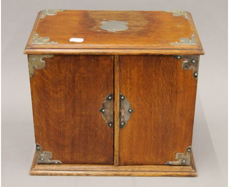 A Victorian oak smoker's tantalus. 33 cm wide.