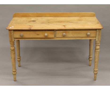 A two-drawer pine side table. 114 cm wide.
