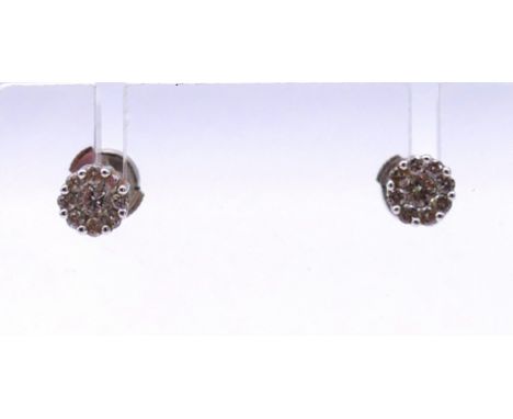 A pair of 18 K white gold and diamond ear studs.  6 mm diameter.
