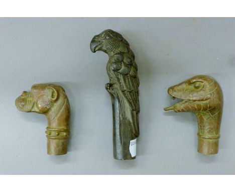 Three bronze walking stick handles. The largest 13 cm high.