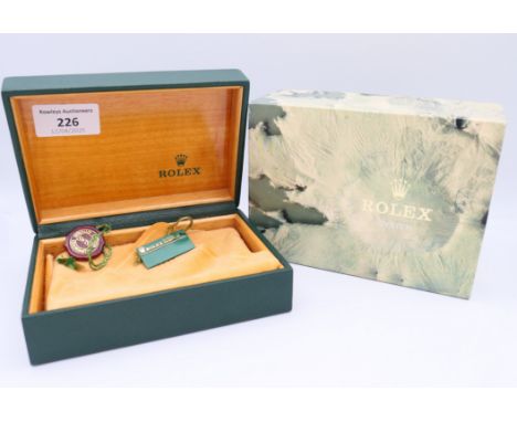 A vacant Rolex watch box with various papers.