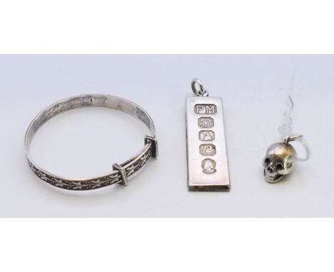 A silver ingot pendant, a silver child's bracelet and a silver plated skull charm.  Ingot 4 cm high. 