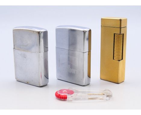 A Dunhill lighter and two Zippo lighters.