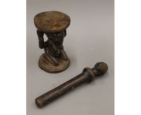 An African wooden stool, the seat supported by a female figure together with a double-headed cylindrical wooden wand. The for