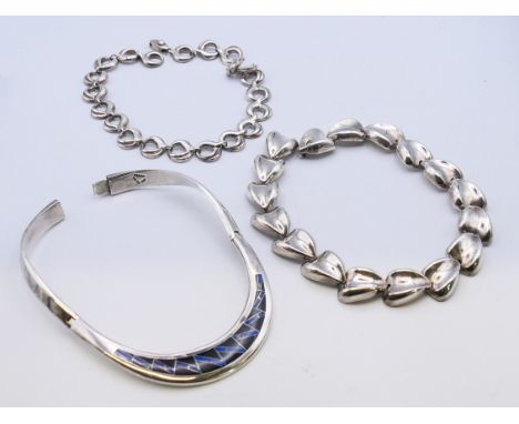 Three silver necklaces, one set with lapis and enamel. The largest 45 cm long. 12.9 troy ounces total weight. 