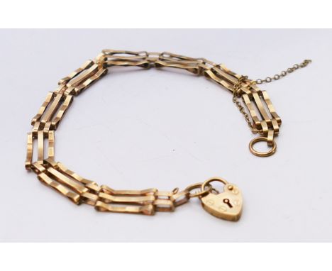 A 9 ct gold three bar gate bracelet with heart padlock.  18 cm long. 5.2 grammes.