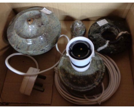 A box containing four Cornish serpentine items comprising small table lamp, larger lamp base and tea light holder and snuffer