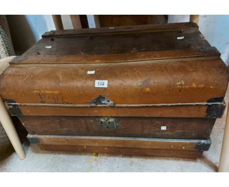 A vintage tin travelling trunk with brown finish and flanking drop handles