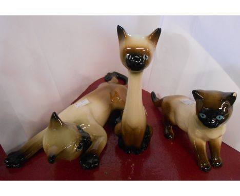 A vintage pottery wall decoration depicting a climbing Siamese cat - sold with two similar figurines