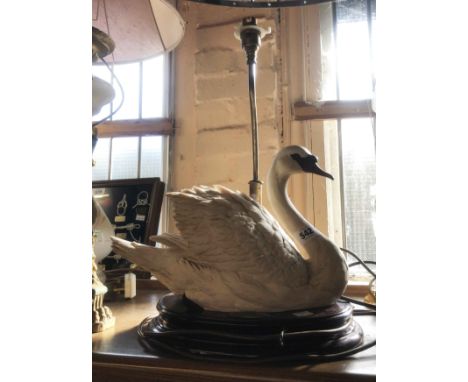 A vintage table lamp, set with large resin swan figurine on a wooden pedestal base with brass lamp to rear - marked with an o