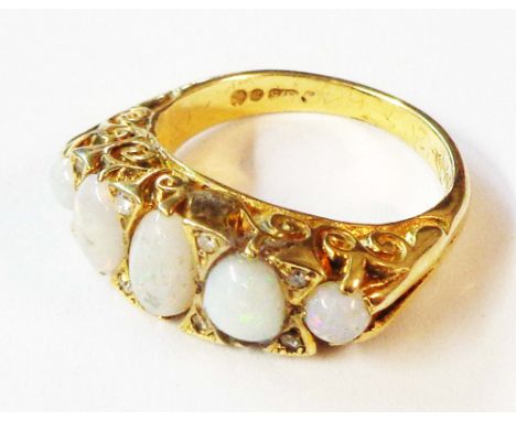 A 375 (9ct.) gold ring, set with five graduated oval opals interspersed with tiny diamonds - size L - boxed