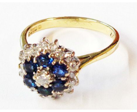 A 750 (18ct.) gold cluster ring, set with central diamond and six sapphires within a diamond border - size O - boxed