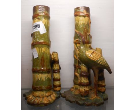 A pair of C.H. Branham Barnstaple art pottery spill vases, each depicting a stork beside a bamboo trunk with coloured slip de