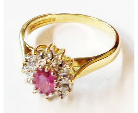 A 750 (18ct.) gold ring, set with central oval ruby within a diamond border - size L - boxed