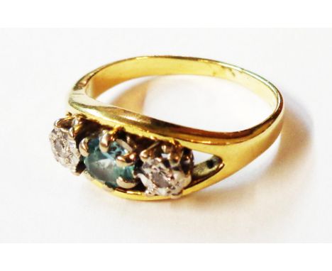 A yellow metal ring (marks worn possibly 9ct.), set with central aquamarine and flanking illusion set diamonds - size L 1/2