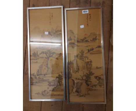 A pair of narrow framed Chinese paintings on silk, each depicting a vista with figures, buildings and trees with mountains in