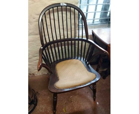 A 20th Century stained wood framed hoop stick back elbow chair with studded upholstery panel to the sectional seat, set on tu