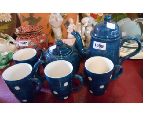 A vintage pottery part tea set comprising teapot, coffee pot and four mugs with blue painted and spotty decoration