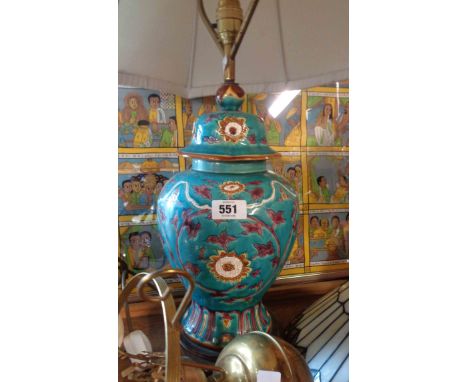 A pottery table lamp of temple jar form with incised decorative scrolls on a blue base ground, set on wooden stand with brass