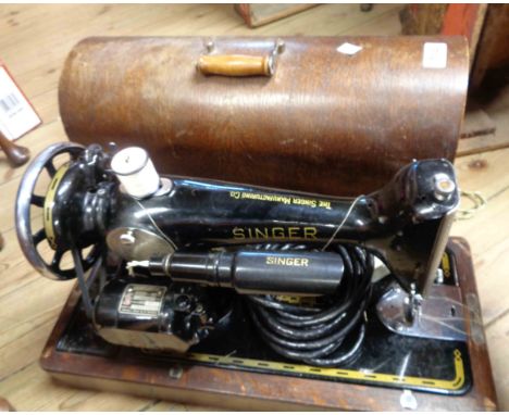 A vintage Singer electric sewing machine with Singer motor and lamp in original wooden dome top case - with accessories
