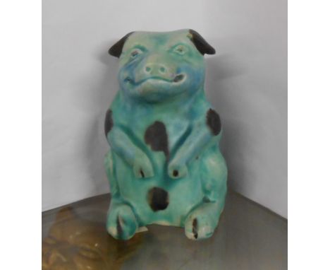 An early 20th Century Baron Barnstaple pottery figurine depicting a comical pig with black painted decoration on a light gree