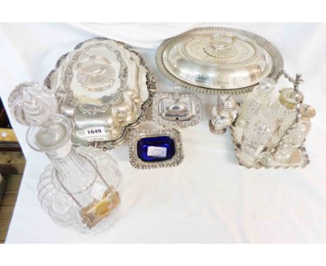 Two silver plated entree dishes, two ornate condiments with blue glass liners and a glass decanter with label