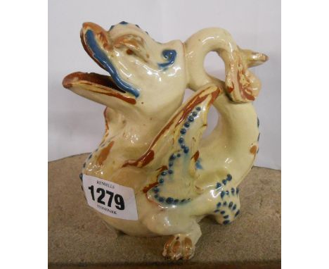 A C.H. Brannam Barnstaple art pottery jug modelled in the form of a gryphon with coloured slip decoration on a cream ground w