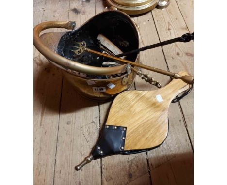 A brass coal scuttle of helmet form, two brass toasting forks, a wrought iron skillet and a vintage brass companion set on st