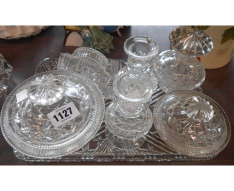 An old cut and moulded glass dressing table set comprising two pots, perfume bottle, pair of candlesticks and trinket box (no