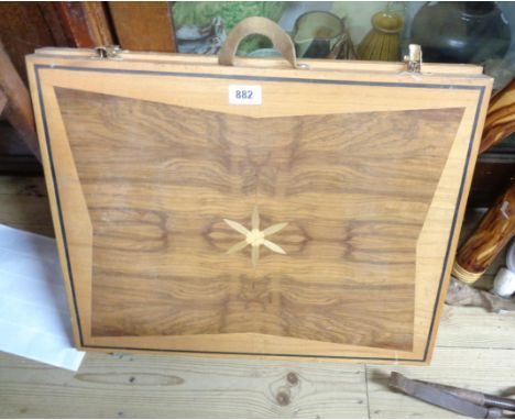 A wooden folding backgammon board with carry handle and decorative inlay