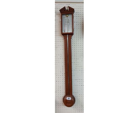 A vintage walnut and strung cased stick barometer with silvered scale and central mercury tube
