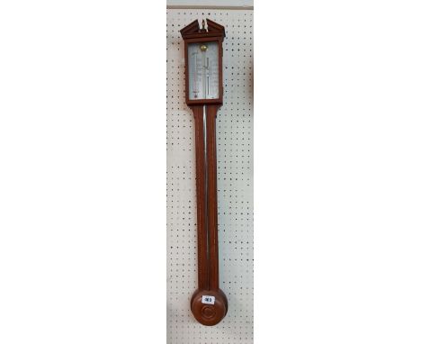 A vintage walnut and strung cased stick barometer with silvered scale and central mercury tube