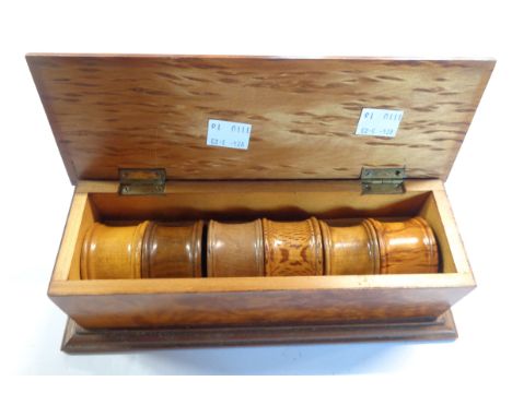 A boxed set of six sample wood napkin rings, each ring turned from a different named exotic timber