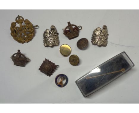 A bag containing a small quantity of cap badges including R.A.F., military and other buttons, yellow metal stick pin, etc.