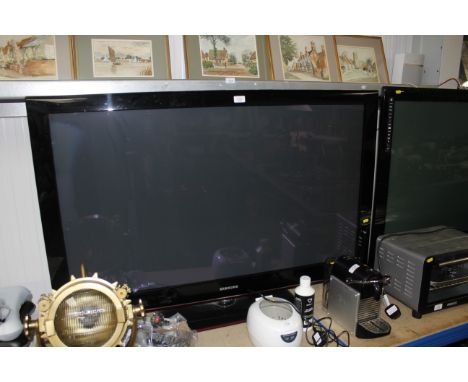 A large Samsung flat screen tv with remote control and user manual 