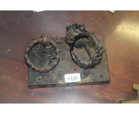 A vintage door lock and two wrought iron door handles 