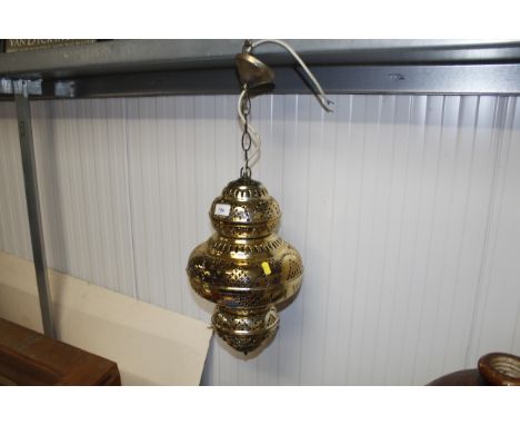 An ornate pierced brass hanging electric lantern