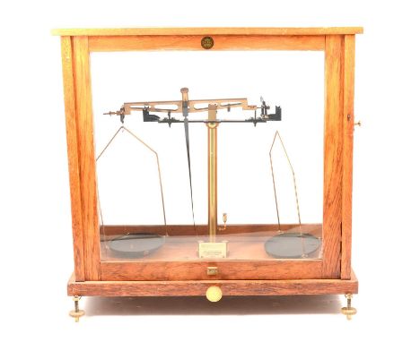 Set of chemical balance scales, oak glazed case, by Baird &amp; Tatlock, London, height 47cm.