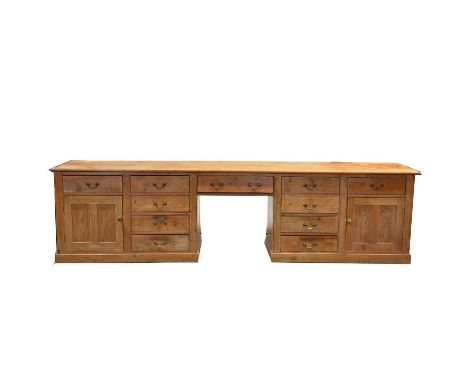 Massive pine farmhouse dresser base, rectangular top, the base with two end sections each with a cupboard and five drawers, c