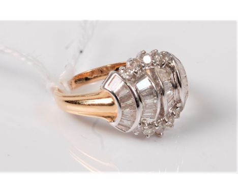 A diamond cluster ring, the mix of tapered bagette cut and round diamonds, all set in white metal, with tapered shoulders and