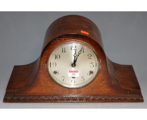 A 1930s oak cased mantel clock, having silvered dial with Arabic numerals and eight day movement