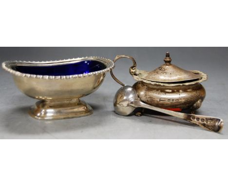 A silver boat shaped mustard, with hinged cover and associated spoon; together with a silver pedestal table salt with blue gl