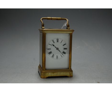A mid 20th century lacquered brass cased carriage clock having enamel dial with Roman numerals, visible platform lever escape