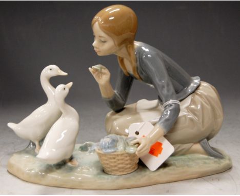 A Lladro porcelain figure group of Girl feeding the ducks, w.23cm