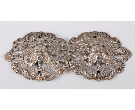 A late Victorian silver belt buckle modelled with a classically styled face and surrounded repousse scrolls and bead work bor