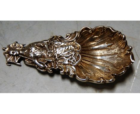 A cast silver caddy spoon the bowl in the form of a shell and the handle in the form of a lady and parasol, London assays