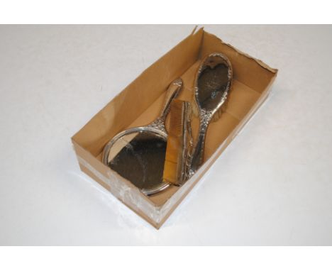 A silver backed dressing table hand mirror; a brush and a comb