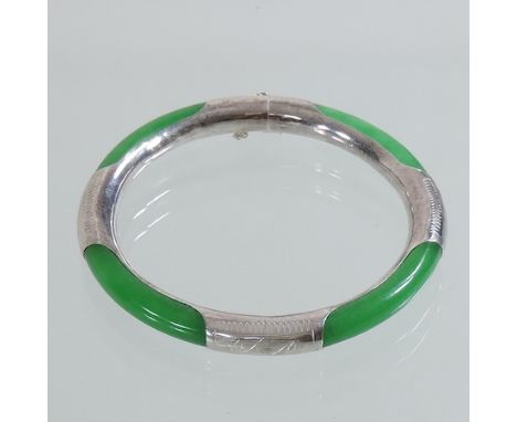 A silver and jade coloured bangle 