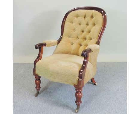 A Victorian cream upholstered button back armchair, on turned legs