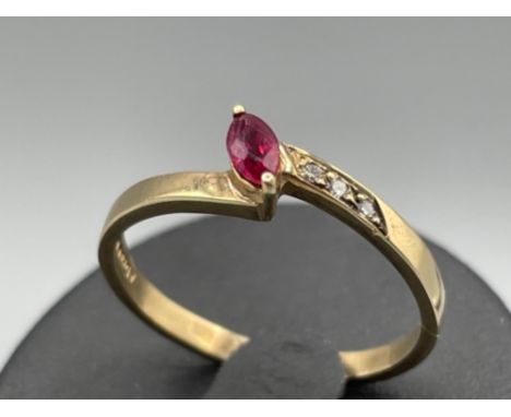 Ladies 9ct gold Ruby and Diamond ring. Featuring a marquise cut ruby and 3 round brilliant cut diamonds set on one side. Size